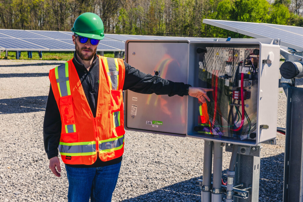 Técnico junto a equipo eléctrico en una planta fotovoltaica